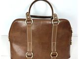 un sac à main en cuir marron à deux anses, orné de ferrures dorées