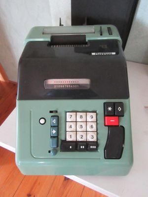 une machine à écrire verte posée sur une table blanche