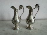 deux vases en argent posés sur une table en marbre