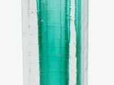 a glass vase with a green liquid inside of it