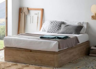 un lit avec une tête de lit en bois et une couverture posée dessus