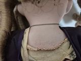 a close up of a doll ' s neck with a chain on it