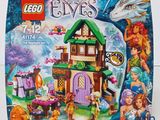 La boîte est ouverte pour montrer le contenu de la maison des elfes Lego.