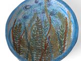 un bol bleu orné d'une peinture représentant un poisson et des plantes