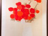 un tableau représentant des fleurs rouges dans un vase, accroché au mur