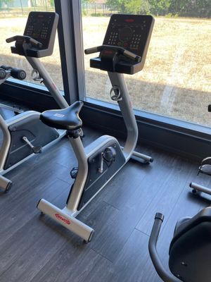 deux vélos d'appartement dans une salle de sport dotée d'une grande fenêtre