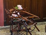 une charrette en bois sur laquelle sont empilées plusieurs chaises en bois