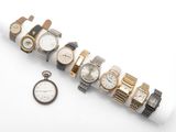 de nombreuses montres et une montre de poche posées sur une surface blanche