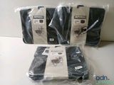four pieces of black clothing are wrapped in plastic bags on a table