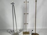 trois lampadaires en métal et en verre posés sur une surface blanche