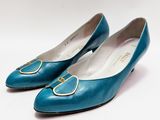 paire de chaussures bleues pour femme avec des boucles dorées sur fond blanc