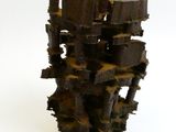 une sculpture réalisée à partir de morceaux de bois posés sur une surface blanche