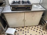 une photo d'une cuisine avec une cuisinière et un tabouret