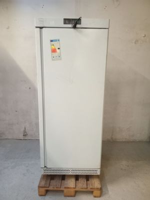 un réfrigérateur blanc posé sur une palette dans une pièce