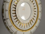 a white and gold plate with a clock on it