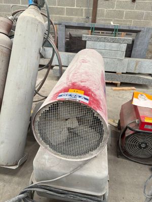 a red blower sitting on the ground next to other blowers