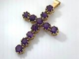 a gold cross with purple stones on a white background