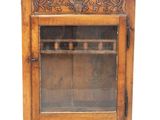 un vieux meuble en bois surmonté d'une porte en verre
