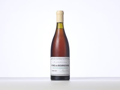 une bouteille de vin posée sur une table blanche