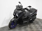 une moto noire garée dans une pièce au sol en damier