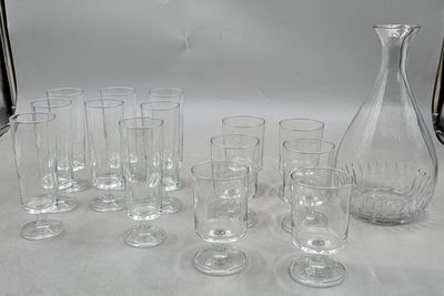 many glasses and a decanter sitting on a table