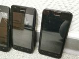 three cell phones sitting next to each other on a white surface