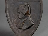 a bronze plaque of a man wearing a helmet on a stand