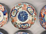 several plates with different designs are arranged on a white surface