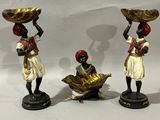 three figurines of women with baskets on their heads