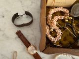a box with a watch, bracelets, and other items on it