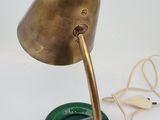 brass table lamp with a green glass shade on a white background