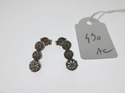a small pair of earrings that are on a table