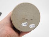 a person holding a small round object with stickers on it