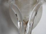 a close up of a wall light with a glass shade on it