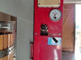 a red machine with a clock on it in a room