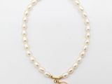 un bracelet en perles avec un fermoir en or et une perle pendante