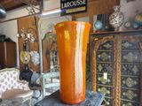 a large orange vase sitting on top of a table in a room
