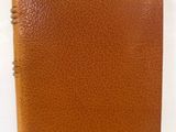 un carnet en cuir marron auquel est attaché un bloc-notes