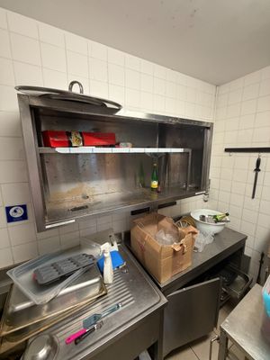une cuisine équipée d'un évier, d'une cuisinière et d'autres éléments posés sur le plan de travail