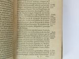 someone is holding a book open on a white surface