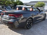 the rear end of a gray bmw convertible parked in a parking lot