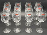six clear wine glasses are lined up in a row on a black surface