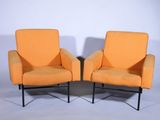 paire de fauteuils de salon rembourrés de couleur orange, avec des pieds en métal noir