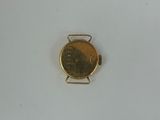 a small gold watch on a white surface