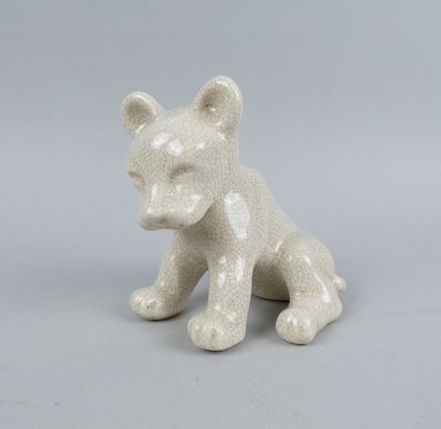 une petite figurine de chat blanc posée sur une table