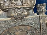 a silver clock with a crown on top of it