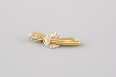 un gros plan d'une broche en or et diamants sur fond blanc