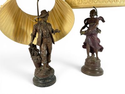 two bronze figurines of a man and a woman with a fan