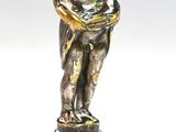 une statue représentant un garçon tenant un bébé dans ses bras, posée sur un socle