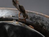 a close up of a black leather hat with a bird perched on it